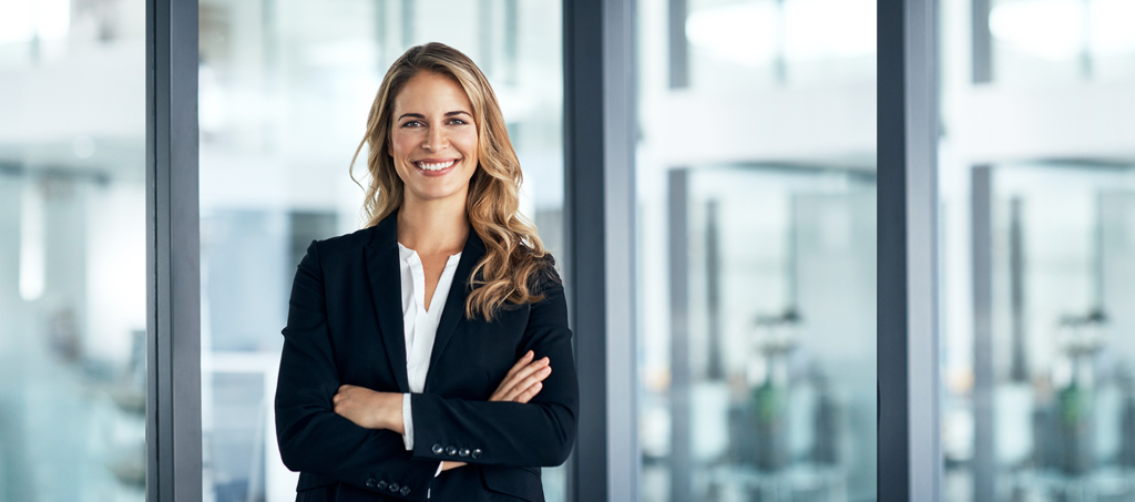 Smiling employee standing in front of window